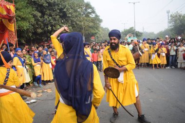 Delhi, Hindistan, 17 Kasım 2024 - Doğu Delhi bölgesinde Guru Nanak Dev, Nagar Kirtan 'ın doğum günü dolayısıyla geleneksel Nagar Kirtan, geleneksel Nagar geçit töreninde Sihler gatka ve dövüş sanatlarını sergiliyor
