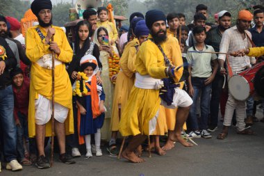 Delhi, Hindistan, 17 Kasım 2024 - Doğu Delhi bölgesinde Guru Nanak Dev, Nagar Kirtan 'ın doğum günü dolayısıyla geleneksel Nagar Kirtan, geleneksel Nagar geçit töreninde Sihler gatka ve dövüş sanatlarını sergiliyor