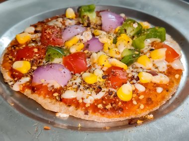 Biberli pizza tahtada, lezzetli ve çıtır vejetaryen pizzanın üst görüntüsü açık kahverengi masa arkasında Margherita.