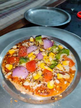 Biberli pizza tahtada, lezzetli ve çıtır vejetaryen pizzanın üst görüntüsü açık kahverengi masa arkasında Margherita.