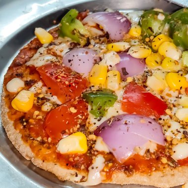 Biberli pizza tahtada, lezzetli ve çıtır vejetaryen pizzanın üst görüntüsü açık kahverengi masa arkasında Margherita.