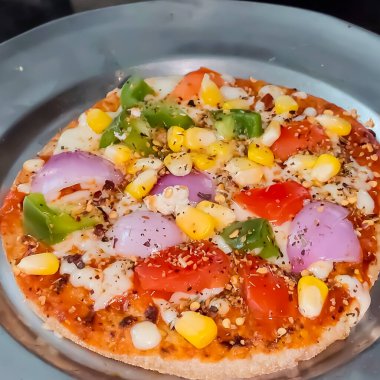 Biberli pizza tahtada, lezzetli ve çıtır vejetaryen pizzanın üst görüntüsü açık kahverengi masa arkasında Margherita.