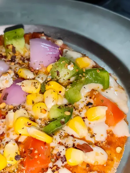 Biberli pizza tahtada, lezzetli ve çıtır vejetaryen pizzanın üst görüntüsü açık kahverengi masa arkasında Margherita.