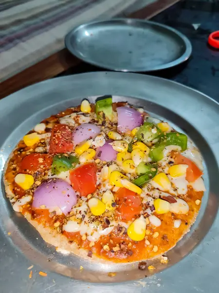 Biberli pizza tahtada, lezzetli ve çıtır vejetaryen pizzanın üst görüntüsü açık kahverengi masa arkasında Margherita.