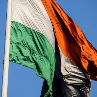 India flag flying high at Connaught Place with pride in blue sky, India flag fluttering, Indian Flag on Independence Day and Republic Day of India, tilt up shot, Waving Indian flag, Har Ghar Tiranga