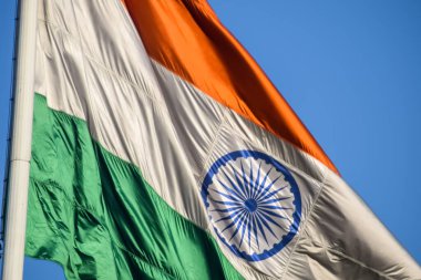 India flag flying high at Connaught Place with pride in blue sky, India flag fluttering, Indian Flag on Independence Day and Republic Day of India, tilt up shot, Waving Indian flag, Har Ghar Tiranga