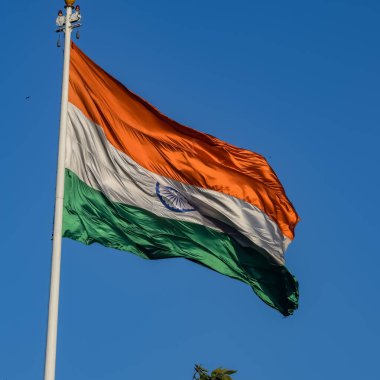 India flag flying high at Connaught Place with pride in blue sky, India flag fluttering, Indian Flag on Independence Day and Republic Day of India, tilt up shot, Waving Indian flag, Har Ghar Tiranga