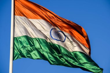 India flag flying high at Connaught Place with pride in blue sky, India flag fluttering, Indian Flag on Independence Day and Republic Day of India, tilt up shot, Waving Indian flag, Har Ghar Tiranga