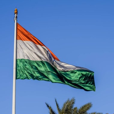 India flag flying high at Connaught Place with pride in blue sky, India flag fluttering, Indian Flag on Independence Day and Republic Day of India, tilt up shot, Waving Indian flag, Har Ghar Tiranga