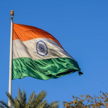 India flag flying high at Connaught Place with pride in blue sky, India flag fluttering, Indian Flag on Independence Day and Republic Day of India, tilt up shot, Waving Indian flag, Har Ghar Tiranga