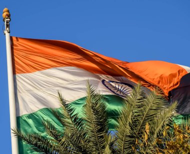 India flag flying high at Connaught Place with pride in blue sky, India flag fluttering, Indian Flag on Independence Day and Republic Day of India, tilt up shot, Waving Indian flag, Har Ghar Tiranga