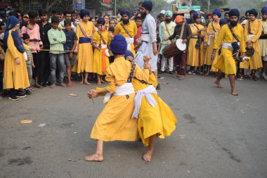 Delhi, Hindistan, 17 Kasım 2024 - Doğu Delhi bölgesinde Guru Nanak Dev, Nagar Kirtan 'ın doğum günü dolayısıyla geleneksel Nagar Kirtan, geleneksel Nagar geçit töreninde Sihler gatka ve dövüş sanatlarını sergiliyor