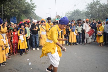 Delhi, Hindistan, 17 Kasım 2024 - Doğu Delhi bölgesinde Guru Nanak Dev, Nagar Kirtan 'ın doğum günü dolayısıyla geleneksel Nagar Kirtan, geleneksel Nagar geçit töreninde Sihler gatka ve dövüş sanatlarını sergiliyor