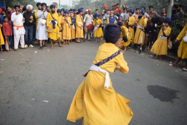 Delhi, Hindistan, 17 Kasım 2024 - Doğu Delhi bölgesinde Guru Nanak Dev, Nagar Kirtan 'ın doğum günü dolayısıyla geleneksel Nagar Kirtan, geleneksel Nagar geçit töreninde Sihler gatka ve dövüş sanatlarını sergiliyor