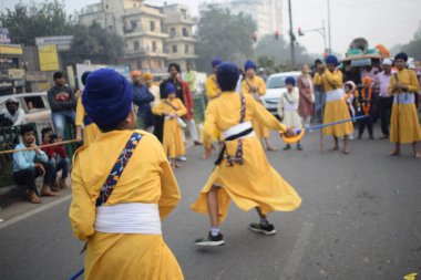 Delhi, Hindistan, 17 Kasım 2024 - Doğu Delhi bölgesinde Guru Nanak Dev, Nagar Kirtan 'ın doğum günü dolayısıyla geleneksel Nagar Kirtan, geleneksel Nagar geçit töreninde Sihler gatka ve dövüş sanatlarını sergiliyor