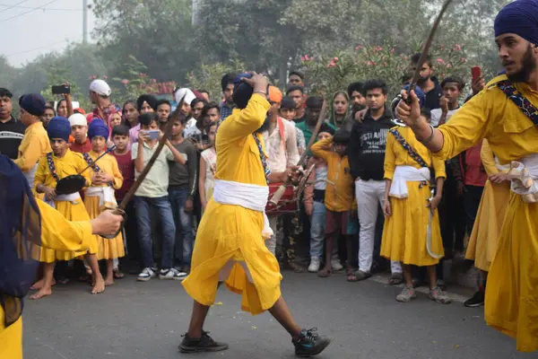 Delhi, Hindistan, 17 Kasım 2024 - Doğu Delhi bölgesinde Guru Nanak Dev, Nagar Kirtan 'ın doğum günü dolayısıyla geleneksel Nagar Kirtan, geleneksel Nagar geçit töreninde Sihler gatka ve dövüş sanatlarını sergiliyor