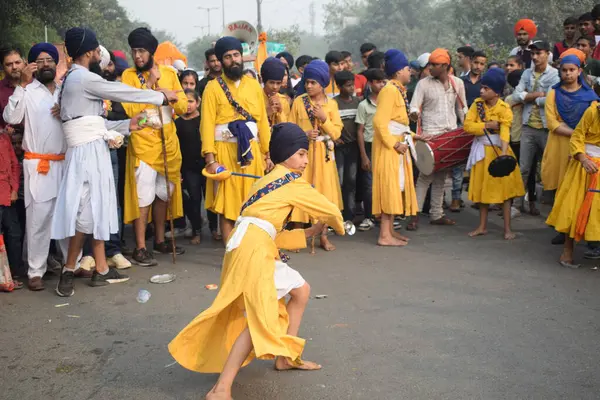 Delhi, Hindistan, 17 Kasım 2024 - Doğu Delhi bölgesinde Guru Nanak Dev, Nagar Kirtan 'ın doğum günü dolayısıyla geleneksel Nagar Kirtan, geleneksel Nagar geçit töreninde Sihler gatka ve dövüş sanatlarını sergiliyor