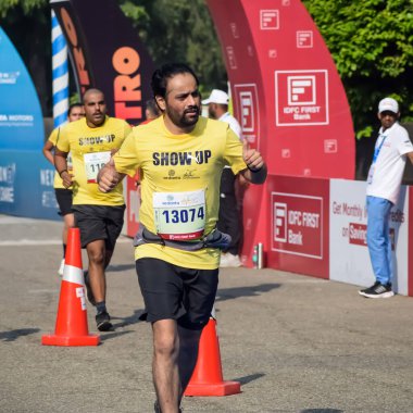 Yeni Delhi, Hindistan - 20 Ekim 2024 - Bitmek üzere olan maraton katılımcılarının bitiş çizgisini geçmek üzere olan Delhi Yarı Maratonu 2024