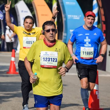 Yeni Delhi, Hindistan - 20 Ekim 2024 - Bitmek üzere olan maraton katılımcılarının bitiş çizgisini geçmek üzere olan Delhi Yarı Maratonu 2024