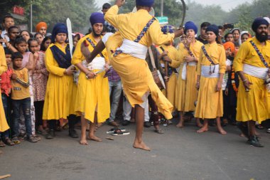 Delhi, Hindistan, 17 Kasım 2024 - Doğu Delhi bölgesinde Guru Nanak Dev, Nagar Kirtan 'ın doğum günü dolayısıyla geleneksel Nagar Kirtan, geleneksel Nagar geçit töreninde Sihler gatka ve dövüş sanatlarını sergiliyor