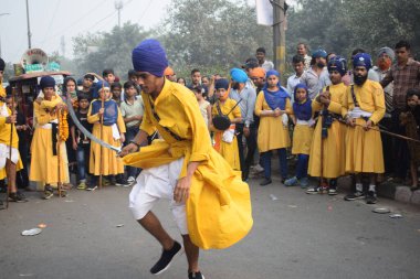 Delhi, Hindistan, 17 Kasım 2024 - Doğu Delhi bölgesinde Guru Nanak Dev, Nagar Kirtan 'ın doğum günü dolayısıyla geleneksel Nagar Kirtan, geleneksel Nagar geçit töreninde Sihler gatka ve dövüş sanatlarını sergiliyor