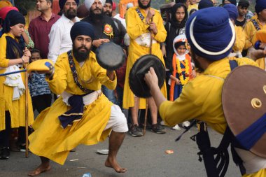 Delhi, Hindistan, 17 Kasım 2024 - Doğu Delhi bölgesinde Guru Nanak Dev, Nagar Kirtan 'ın doğum günü dolayısıyla geleneksel Nagar Kirtan, geleneksel Nagar geçit töreninde Sihler gatka ve dövüş sanatlarını sergiliyor