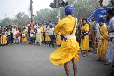 Delhi, Hindistan, 17 Kasım 2024 - Doğu Delhi bölgesinde Guru Nanak Dev, Nagar Kirtan 'ın doğum günü dolayısıyla geleneksel Nagar Kirtan, geleneksel Nagar geçit töreninde Sihler gatka ve dövüş sanatlarını sergiliyor