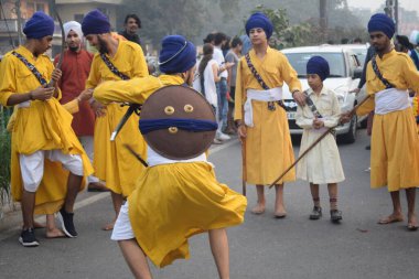 Delhi, Hindistan, 17 Kasım 2024 - Doğu Delhi bölgesinde Guru Nanak Dev, Nagar Kirtan 'ın doğum günü dolayısıyla geleneksel Nagar Kirtan, geleneksel Nagar geçit töreninde Sihler gatka ve dövüş sanatlarını sergiliyor