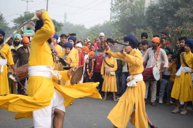 Delhi, Hindistan, 17 Kasım 2024 - Doğu Delhi bölgesinde Guru Nanak Dev, Nagar Kirtan 'ın doğum günü dolayısıyla geleneksel Nagar Kirtan, geleneksel Nagar geçit töreninde Sihler gatka ve dövüş sanatlarını sergiliyor