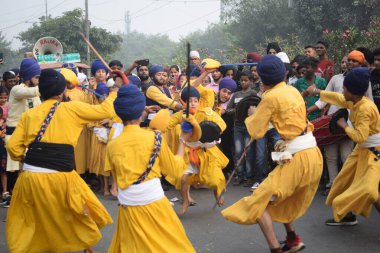 Delhi, Hindistan, 17 Kasım 2024 - Doğu Delhi bölgesinde Guru Nanak Dev, Nagar Kirtan 'ın doğum günü dolayısıyla geleneksel Nagar Kirtan, geleneksel Nagar geçit töreninde Sihler gatka ve dövüş sanatlarını sergiliyor