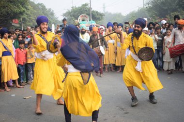 Delhi, Hindistan, 17 Kasım 2024 - Doğu Delhi bölgesinde Guru Nanak Dev, Nagar Kirtan 'ın doğum günü dolayısıyla geleneksel Nagar Kirtan, geleneksel Nagar geçit töreninde Sihler gatka ve dövüş sanatlarını sergiliyor