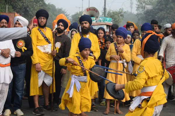 Delhi, Hindistan, 17 Kasım 2024 - Doğu Delhi bölgesinde Guru Nanak Dev, Nagar Kirtan 'ın doğum günü dolayısıyla geleneksel Nagar Kirtan, geleneksel Nagar geçit töreninde Sihler gatka ve dövüş sanatlarını sergiliyor