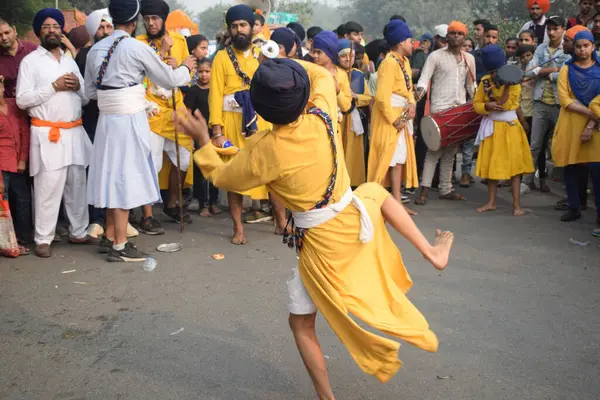 Delhi, Hindistan, 17 Kasım 2024 - Doğu Delhi bölgesinde Guru Nanak Dev, Nagar Kirtan 'ın doğum günü dolayısıyla geleneksel Nagar Kirtan, geleneksel Nagar geçit töreninde Sihler gatka ve dövüş sanatlarını sergiliyor
