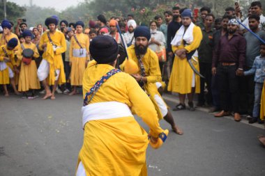 Delhi, Hindistan, 17 Kasım 2024 - Doğu Delhi bölgesinde Guru Nanak Dev, Nagar Kirtan 'ın doğum günü dolayısıyla geleneksel Nagar Kirtan, geleneksel Nagar geçit töreninde Sihler gatka ve dövüş sanatlarını sergiliyor
