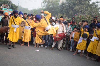 Delhi, Hindistan, 17 Kasım 2024 - Doğu Delhi bölgesinde Guru Nanak Dev, Nagar Kirtan 'ın doğum günü dolayısıyla geleneksel Nagar Kirtan, geleneksel Nagar geçit töreninde Sihler gatka ve dövüş sanatlarını sergiliyor