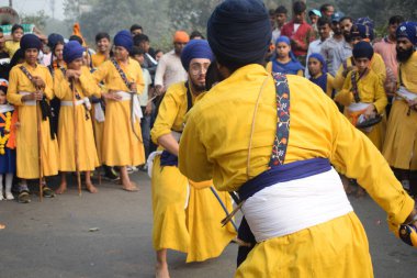 Delhi, Hindistan, 17 Kasım 2024 - Doğu Delhi bölgesinde Guru Nanak Dev, Nagar Kirtan 'ın doğum günü dolayısıyla geleneksel Nagar Kirtan, geleneksel Nagar geçit töreninde Sihler gatka ve dövüş sanatlarını sergiliyor