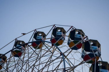 Delhi, Hindistan 'da Dussehra Mela sırasında çok renkli Dev Tekerlek' in yakın çekimi. Dev tekerlek salıncağının alt görüntüsü. Akşam vakti renkli kamaraları olan dönme dolap..