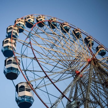 Delhi, Hindistan 'da Dussehra Mela sırasında çok renkli Dev Tekerlek' in yakın çekimi. Dev tekerlek salıncağının alt görüntüsü. Akşam vakti renkli kamaraları olan dönme dolap..