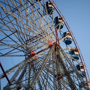 Delhi, Hindistan 'da Dussehra Mela sırasında çok renkli Dev Tekerlek' in yakın çekimi. Dev tekerlek salıncağının alt görüntüsü. Akşam vakti renkli kamaraları olan dönme dolap..