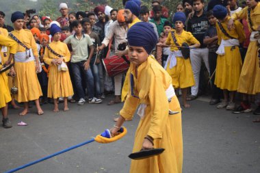 Delhi, Hindistan, 17 Kasım 2024 - Doğu Delhi bölgesinde Guru Nanak Dev, Nagar Kirtan 'ın doğum günü dolayısıyla geleneksel Nagar Kirtan, geleneksel Nagar geçit töreninde Sihler gatka ve dövüş sanatlarını sergiliyor