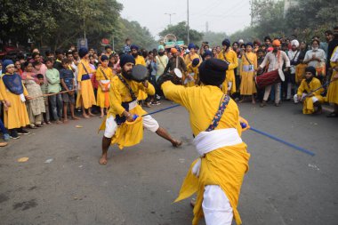 Delhi, Hindistan, 17 Kasım 2024 - Doğu Delhi bölgesinde Guru Nanak Dev, Nagar Kirtan 'ın doğum günü dolayısıyla geleneksel Nagar Kirtan, geleneksel Nagar geçit töreninde Sihler gatka ve dövüş sanatlarını sergiliyor