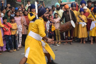 Delhi, Hindistan, 17 Kasım 2024 - Doğu Delhi bölgesinde Guru Nanak Dev, Nagar Kirtan 'ın doğum günü dolayısıyla geleneksel Nagar Kirtan, geleneksel Nagar geçit töreninde Sihler gatka ve dövüş sanatlarını sergiliyor