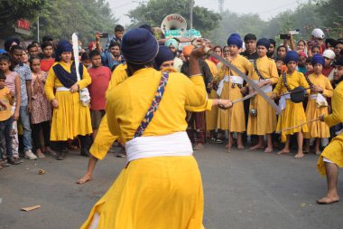 Delhi, Hindistan, 17 Kasım 2024 - Doğu Delhi bölgesinde Guru Nanak Dev, Nagar Kirtan 'ın doğum günü dolayısıyla geleneksel Nagar Kirtan, geleneksel Nagar geçit töreninde Sihler gatka ve dövüş sanatlarını sergiliyor