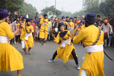 Delhi, Hindistan, 17 Kasım 2024 - Doğu Delhi bölgesinde Guru Nanak Dev, Nagar Kirtan 'ın doğum günü dolayısıyla geleneksel Nagar Kirtan, geleneksel Nagar geçit töreninde Sihler gatka ve dövüş sanatlarını sergiliyor