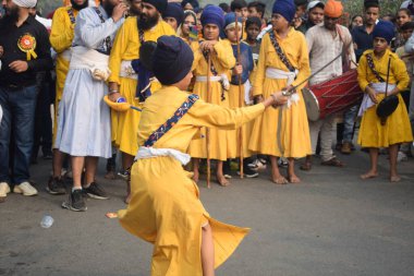 Delhi, Hindistan, 17 Kasım 2024 - Doğu Delhi bölgesinde Guru Nanak Dev, Nagar Kirtan 'ın doğum günü dolayısıyla geleneksel Nagar Kirtan, geleneksel Nagar geçit töreninde Sihler gatka ve dövüş sanatlarını sergiliyor