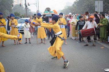 Delhi, Hindistan, 17 Kasım 2024 - Doğu Delhi bölgesinde Guru Nanak Dev, Nagar Kirtan 'ın doğum günü dolayısıyla geleneksel Nagar Kirtan, geleneksel Nagar geçit töreninde Sihler gatka ve dövüş sanatlarını sergiliyor