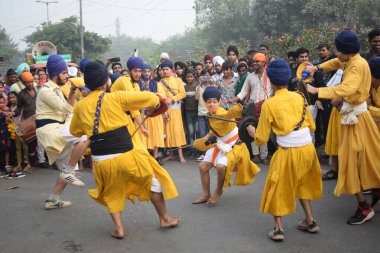 Delhi, Hindistan, 17 Kasım 2024 - Doğu Delhi bölgesinde Guru Nanak Dev, Nagar Kirtan 'ın doğum günü dolayısıyla geleneksel Nagar Kirtan, geleneksel Nagar geçit töreninde Sihler gatka ve dövüş sanatlarını sergiliyor