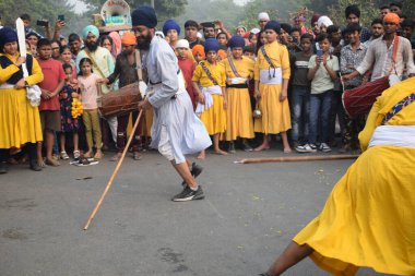 Delhi, Hindistan, 17 Kasım 2024 - Doğu Delhi bölgesinde Guru Nanak Dev, Nagar Kirtan 'ın doğum günü dolayısıyla geleneksel Nagar Kirtan, geleneksel Nagar geçit töreninde Sihler gatka ve dövüş sanatlarını sergiliyor