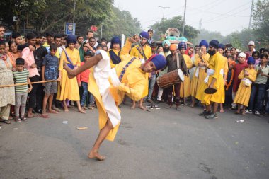 Delhi, Hindistan, 17 Kasım 2024 - Doğu Delhi bölgesinde Guru Nanak Dev, Nagar Kirtan 'ın doğum günü dolayısıyla geleneksel Nagar Kirtan, geleneksel Nagar geçit töreninde Sihler gatka ve dövüş sanatlarını sergiliyor