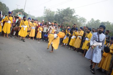 Delhi, Hindistan, 17 Kasım 2024 - Doğu Delhi bölgesinde Guru Nanak Dev, Nagar Kirtan 'ın doğum günü dolayısıyla geleneksel Nagar Kirtan, geleneksel Nagar geçit töreninde Sihler gatka ve dövüş sanatlarını sergiliyor